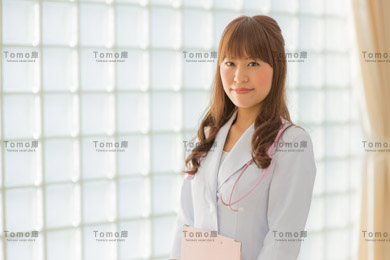 病院内に立つ若い女性医師の画像