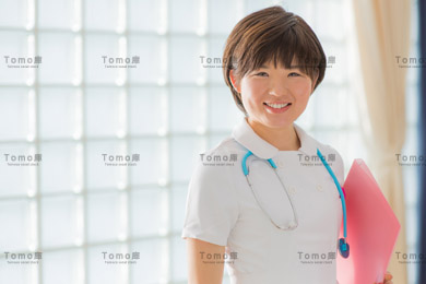 病院内に立つ笑顔の女性看護師（ナース）の画像