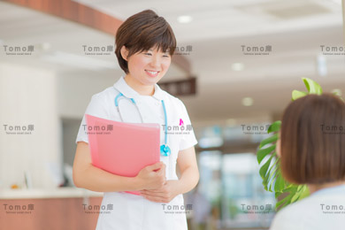 患者に微笑む女性看護師（ナース）の画像