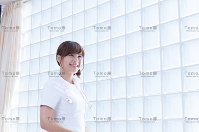 病院内に立つ微笑む女性看護師（ナース）の画像