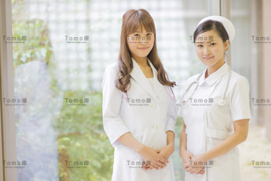病院内に立つ女性医師と女性看護師（ナース）の画像