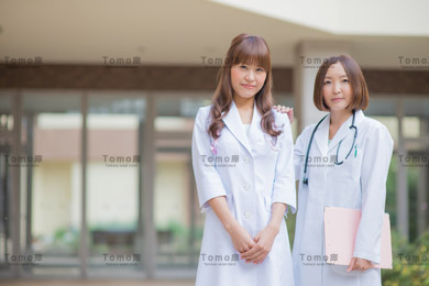 病院の中庭に立つ女性医師2名の画像