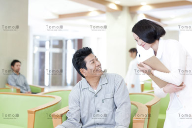 待合室の男性患者と女性看護師の画像