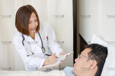 入院中の男性患者に話しかける女性医師の画像