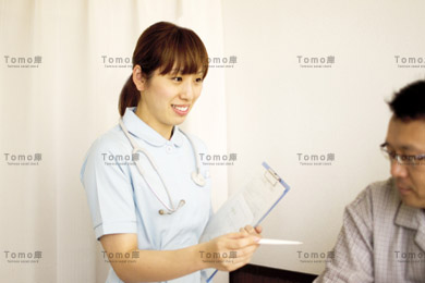 入院中の男性患者に話しかける女性看護師（ナース）の画像