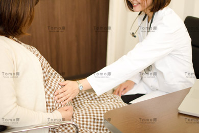 妊婦を診察する女性医師の画像